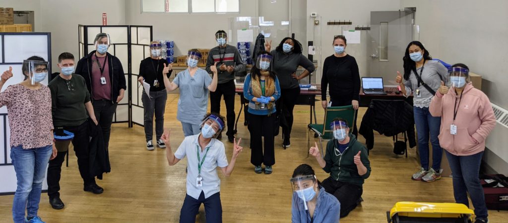 a group of healthcare workers socially distanced with PPE on