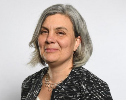 Monica wearing a black blazer and silver necklace