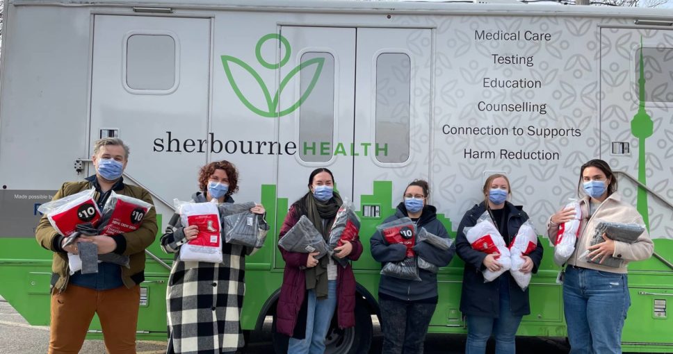 group of people holding up bags of socks